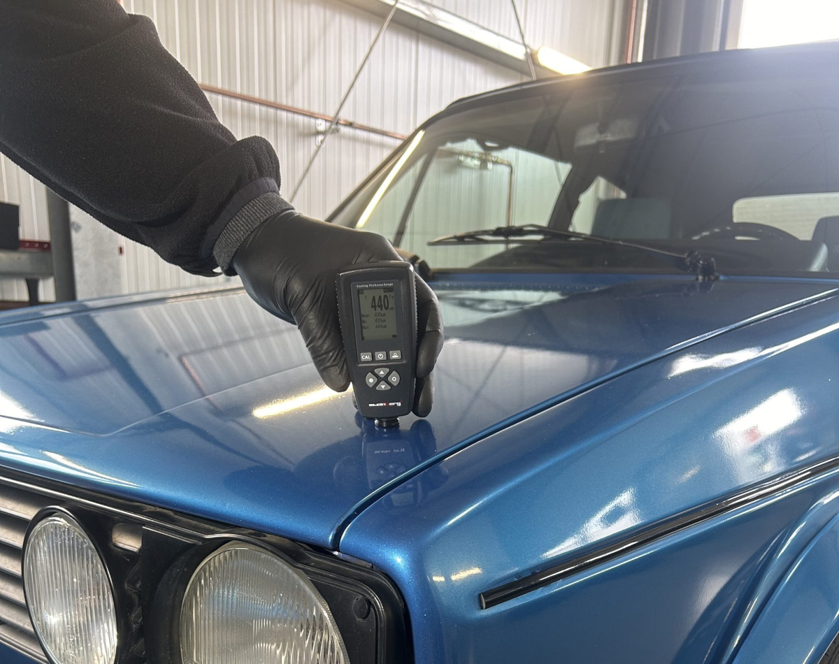 Ein KFZ-Sachverständiger misst mit einem Lackschichtdicken-Messgerät die Dicke der Lackschicht eines Fahrzeugs, um eine präzise Fahrzeugbewertung vorzunehmen. Ideal für die professionelle Schadensanalyse und Fahrzeuginspektion.